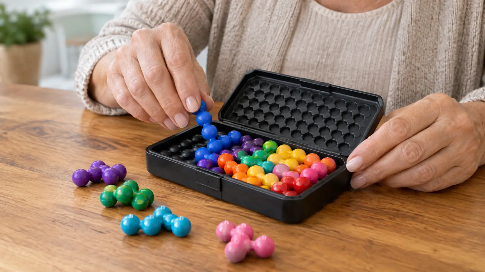 Hands fitting the puzzle pieces into the tray of the game on a wooden table.